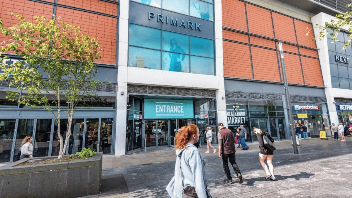 a group of people walking outside a shopping centre
